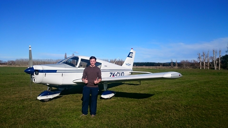 Me standing infront of a Piper Cherokee after my first solo flight